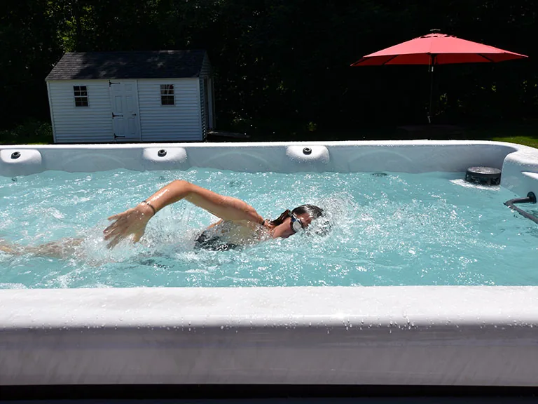 Swimmer exercising against the current in an outdoor swim spa